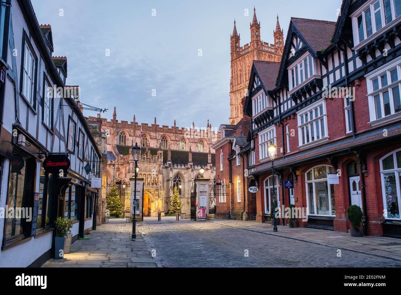 College street with shops and Gloucester Cathedral on Christmas Day at dusk. Gloucester, Gloucestershire, Cotswolds, England Stock Photo