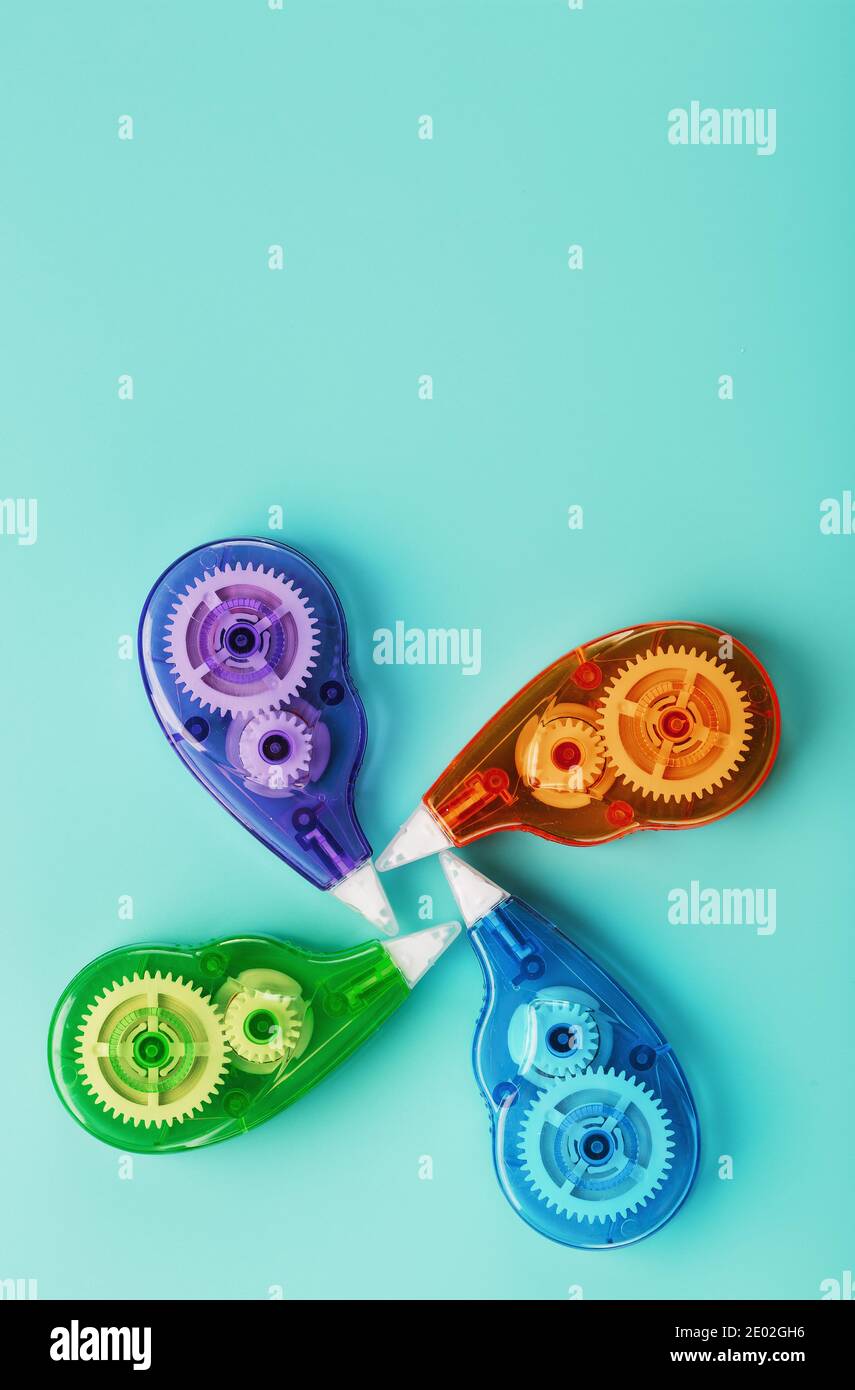 Stationery correction tapes are Multicolored on a blue background. Free space. The view from the top. Blue, green, yellow, lilac Stock Photo