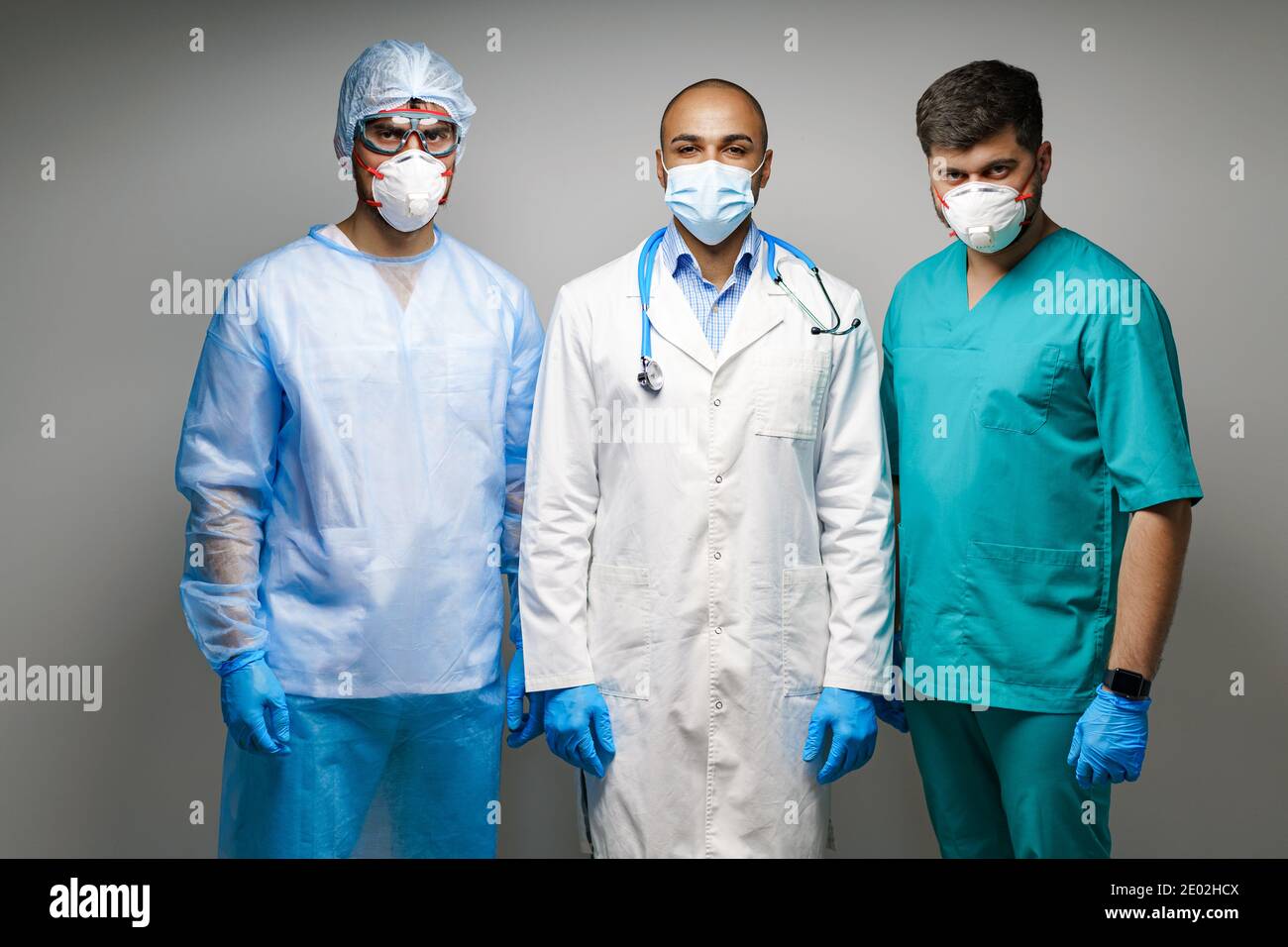 Doctors In Uniform Male doctors in medical uniform wearing masks standing against grey ...