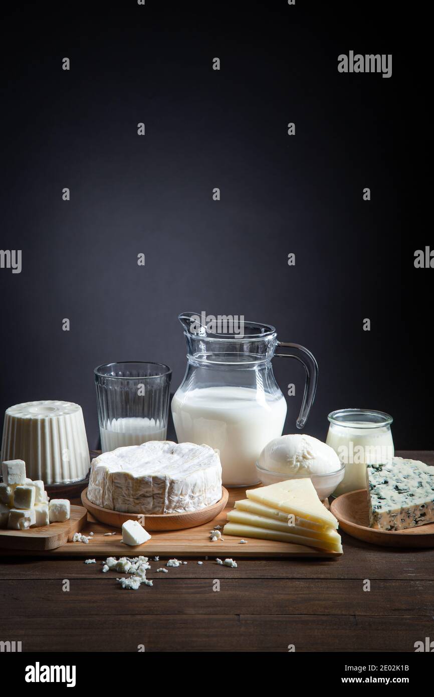 Dairy products on  wooden base and dark background with copy space, vertical format. Stock Photo