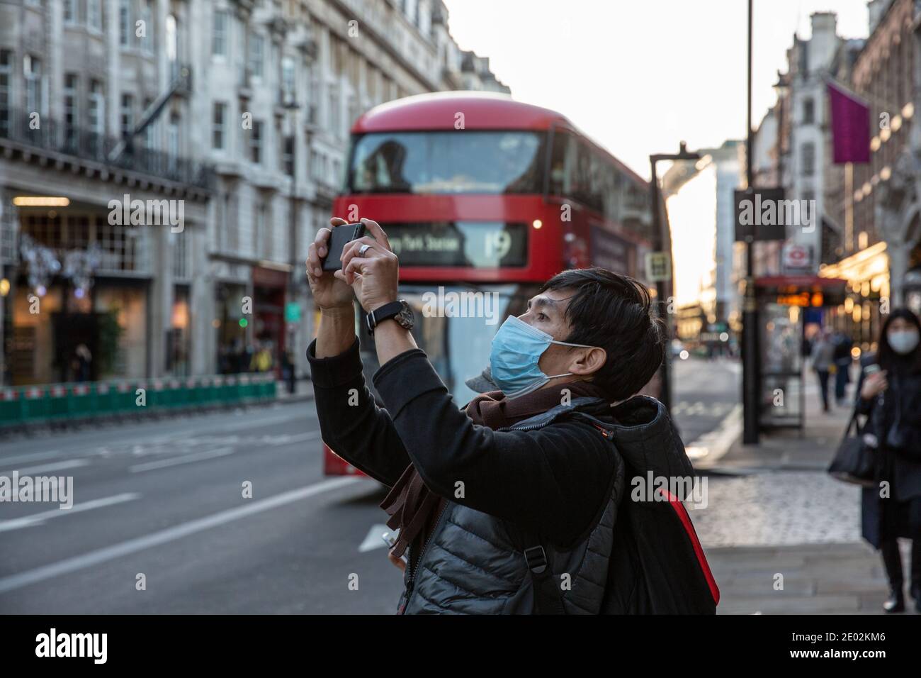Asian tourist taking a selfie on Piccadilly during the Tier4 Coronavirus Lockdown in Central London, England, United Kingdom Stock Photo