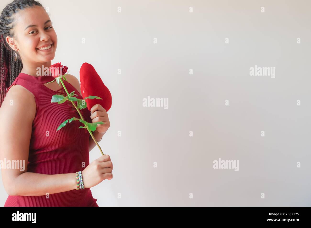 Girl holding red heart and rose for birthday. Beautiful young happy ...