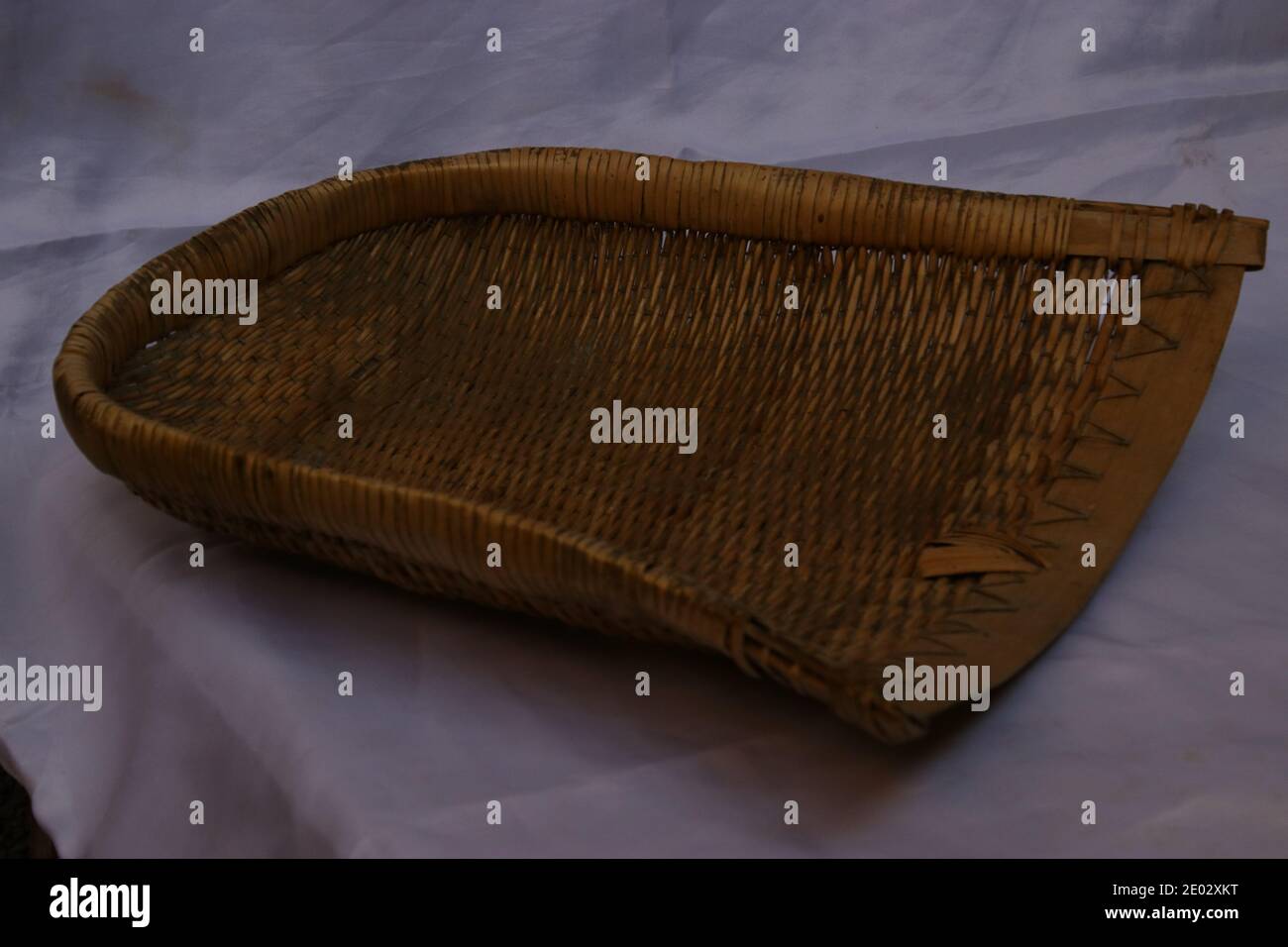 Old handmade wicker dustpan isolated. Handmade storage basket Stock Photo