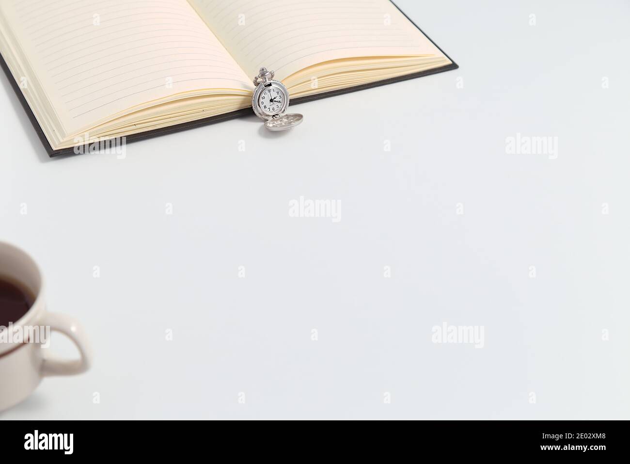 Classic pocket watch, notebook, coffee on the desk, white copy space background, coronavirus pandemic, work from home Stock Photo