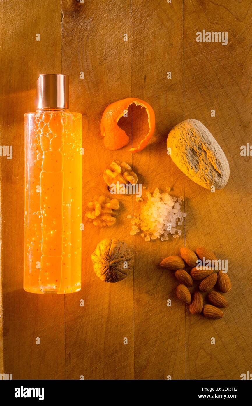 Studio still-life image of microplastics alternatives, with a bottle of shampoo, walnuts, walnut shells, orange peel, pumice, rock salt, and almonds. Stock Photo