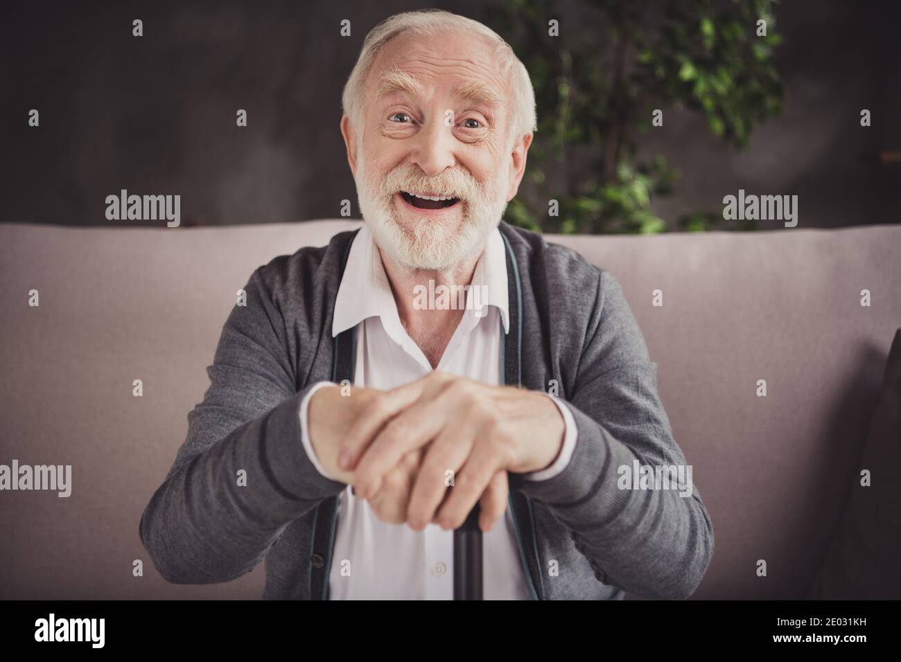 Photo of charming smiling pensioner wear grey cardigan arms hands nursery stick indoors house flat Stock Photo