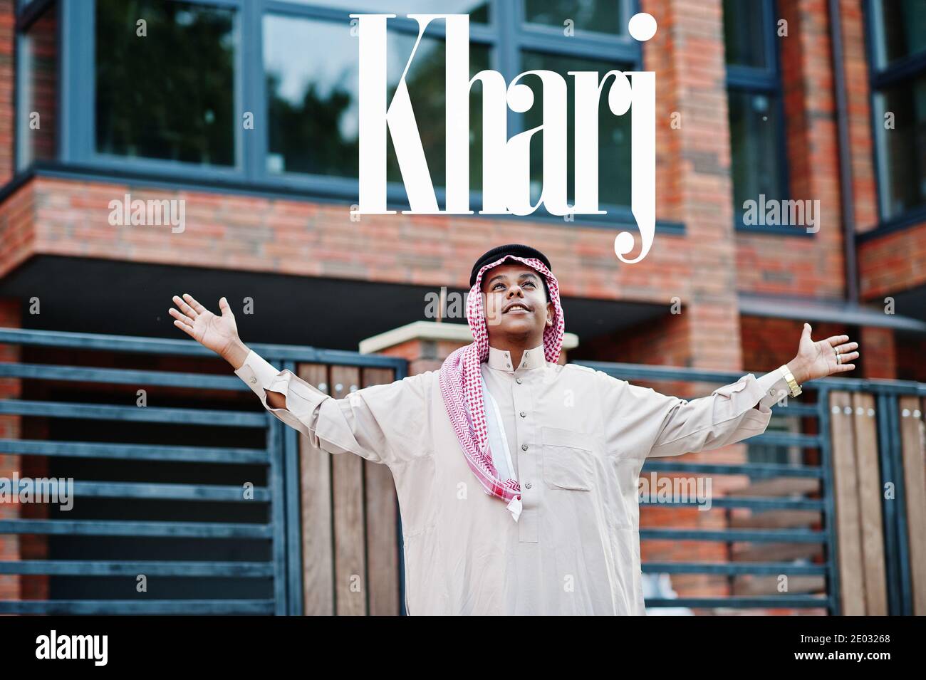 Kharj - biggest city of Saudi Arabia. Middle Eastern saudi arabian man posed on street against modern building up his hands in the air. Stock Photo