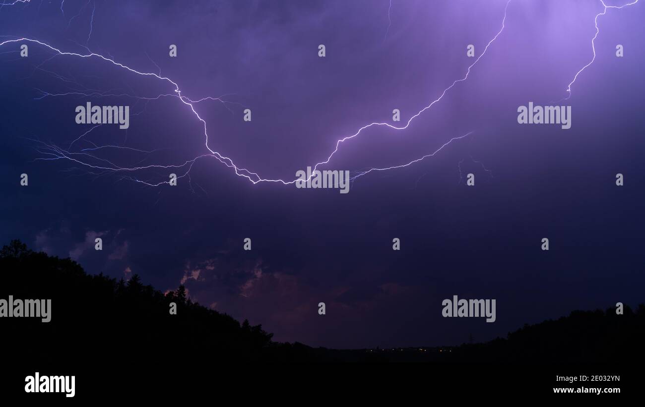 Purple lightning over the city at night Stock Photo