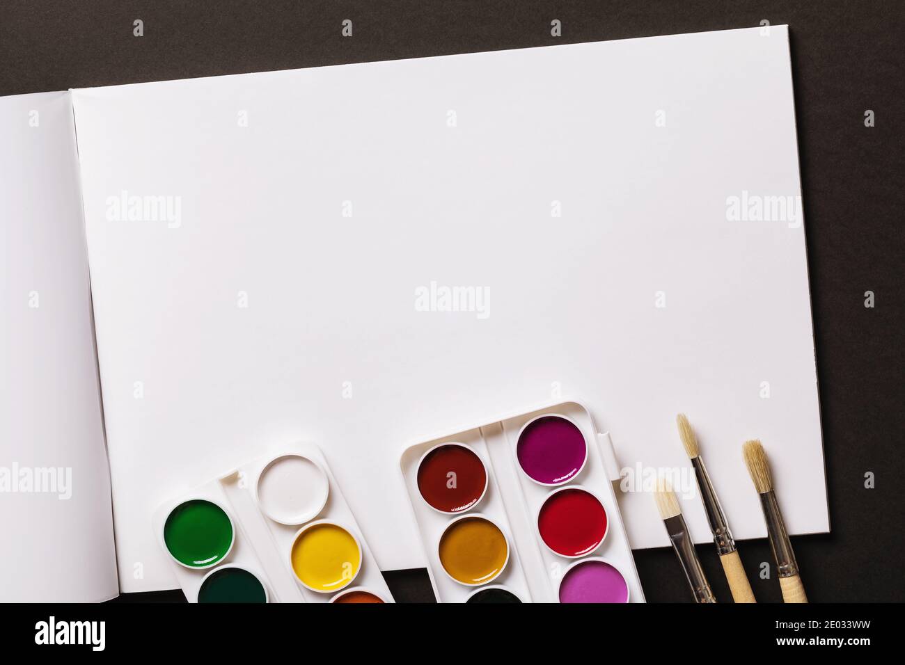 Open sketchbook with watercolor paints and brushes on dark wooden  background, An open notebook on the table top view, AI Generated 24570430  Stock Photo at Vecteezy