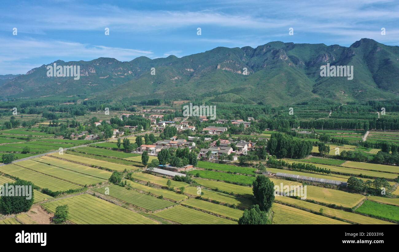 Aerial view of green mountains and village on a clear sunny summer day ...