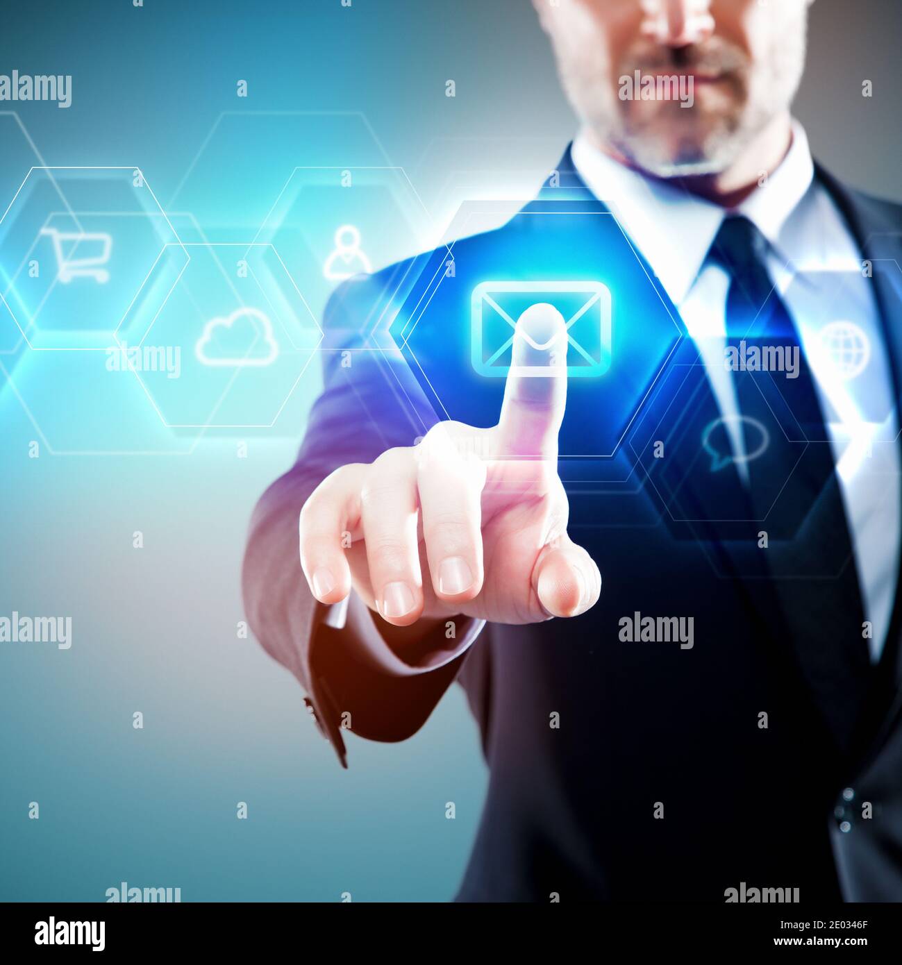 Businessman touching a blue futuristic digital screen, email symbol / icon Stock Photo