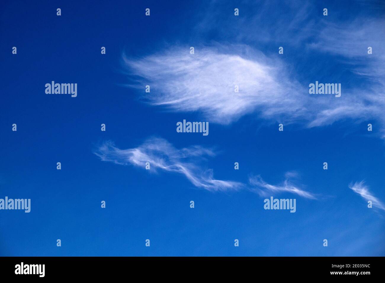 Wispy white cirrus clouds in blue sky background with copy space ...