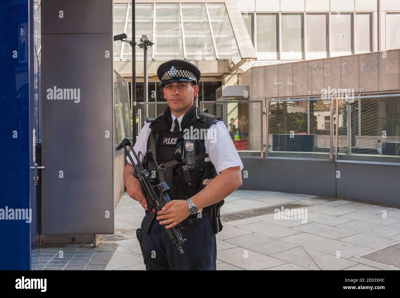 An armed Metropolitan Police Officer on duty outside New Scotland Yard in London, England, UK Stock Photo