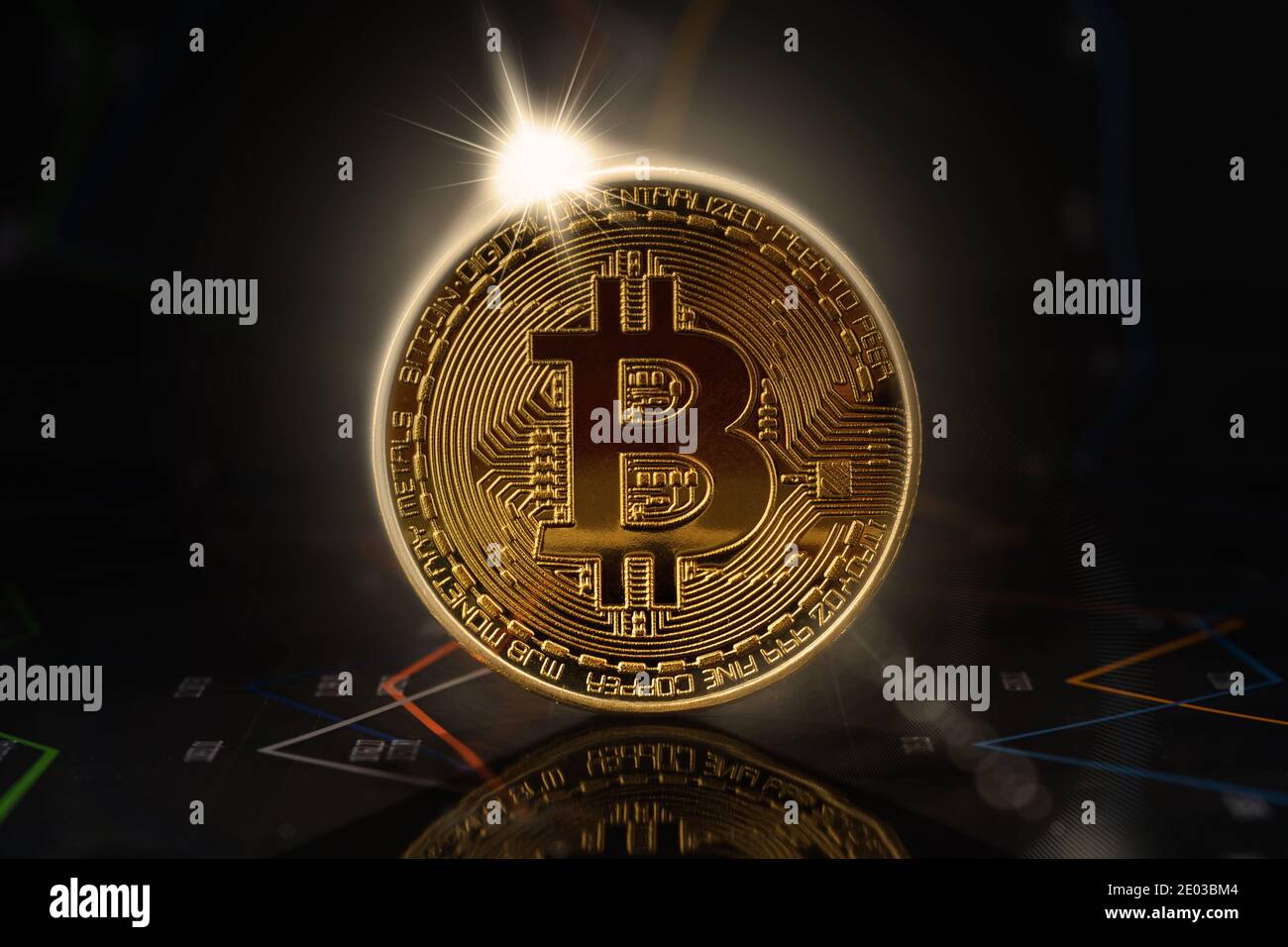 Sunrise behind gold bitcoin standing on financial graphs for cryptocurrency prices Stock Photo