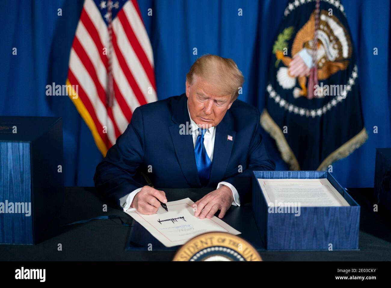 U.S President Donald Trump, signs the Consolidated Appropriations Act, 2021 in the Tea Room at Mar-a-Lago December 27, 2020 in Palm Beach, Florida. Credit: Planetpix/Alamy Live News Stock Photo
