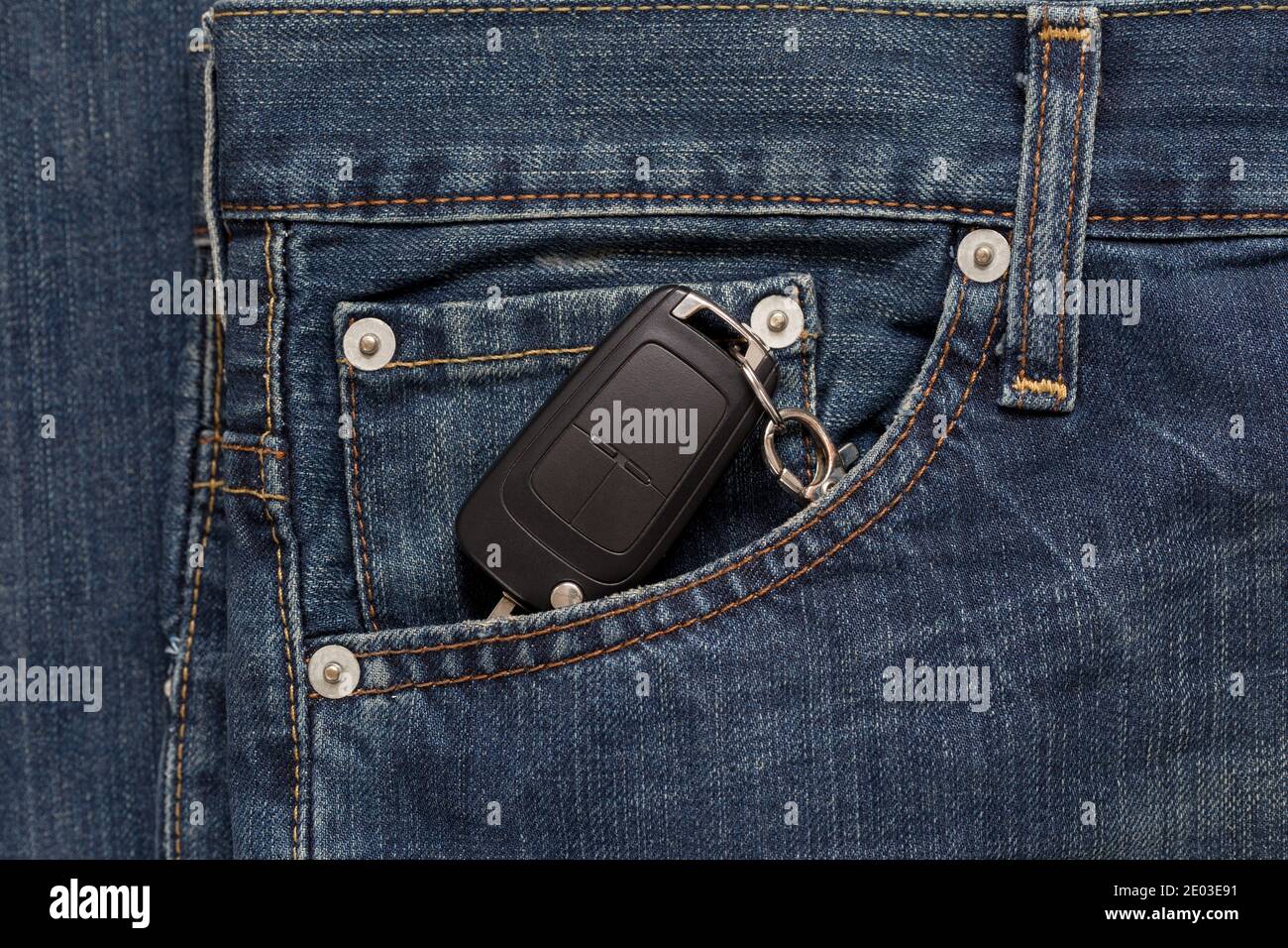 Ignition key is lying in side pocket of blue jeans. Modern lifestyle. Stock Photo