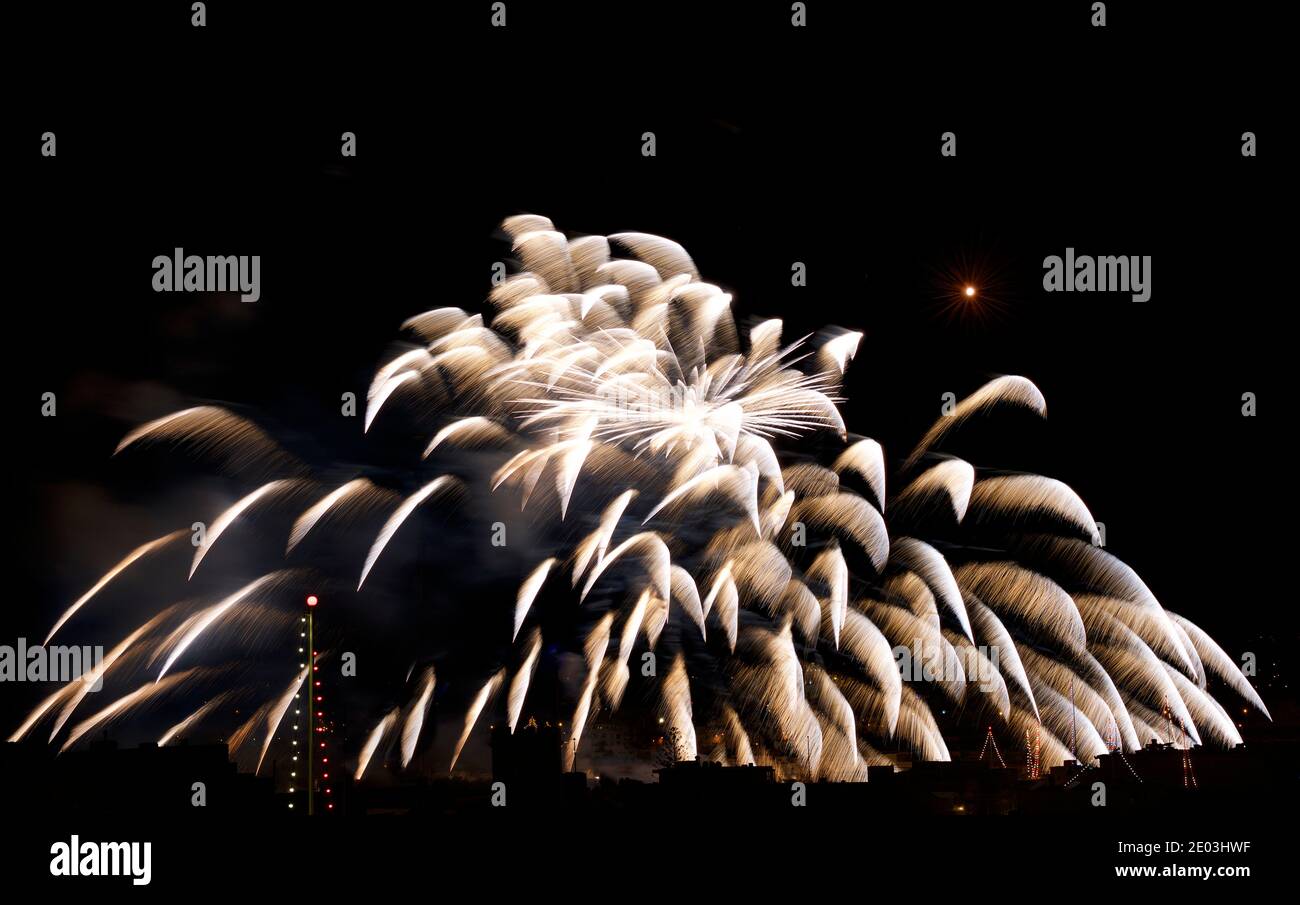 Fireworks. Colorful huge fireworks explode in dark sky background and house light in the far in Zurrieq, Malta Malta fireworks festival, 4 of July, In Stock Photo