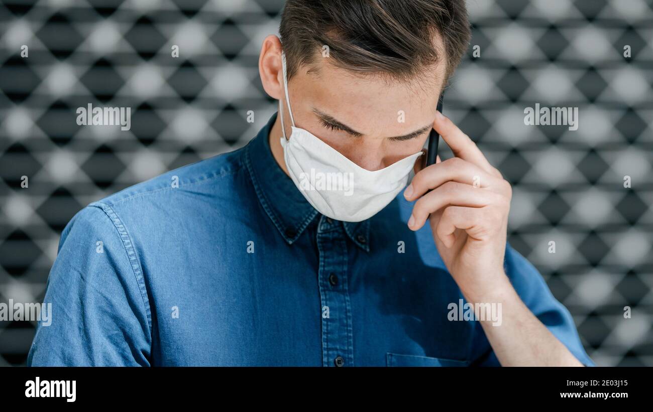 close up. attractive young man in a protective mask talking on a ...