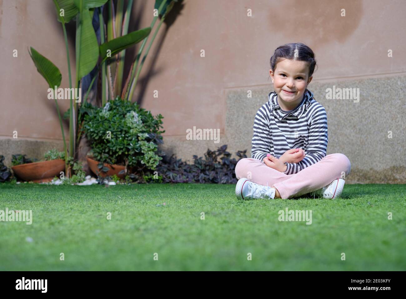 Happy girl sitting on the grass Stock Photo - Alamy