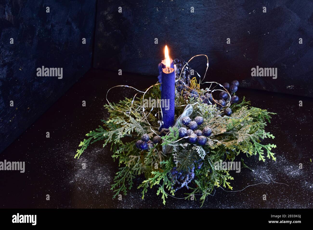 Christmas decoration with candles in blue-green colors on a black