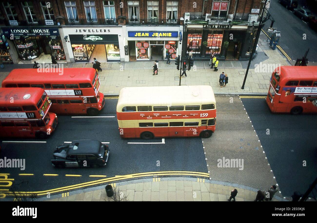 london buses in Oxford street with Jean Jeanie store and Laura Ashley retail outlet Stock Photo