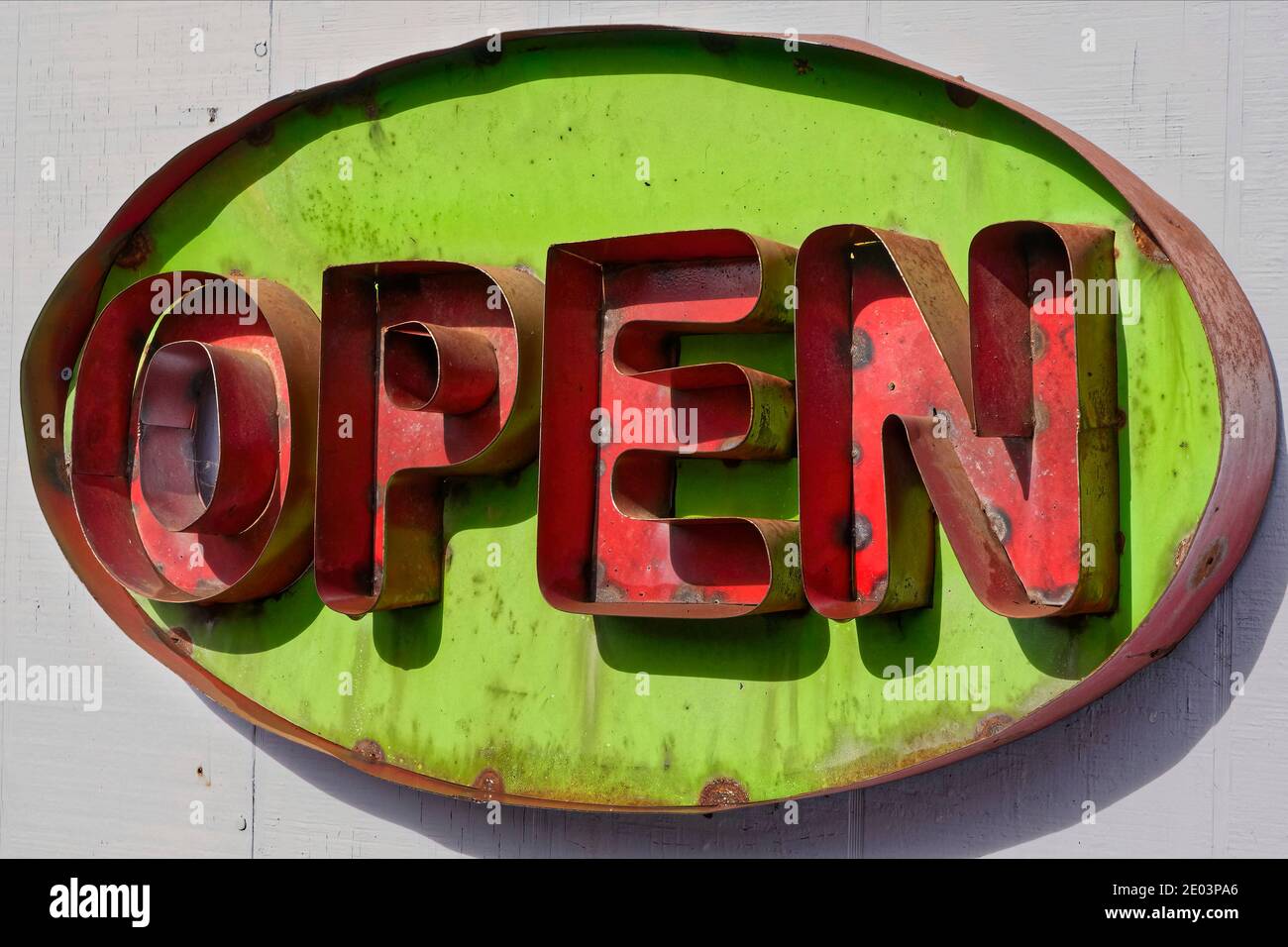 An old, metal, vivid lime green and red Open sign in Santa Rosa, CA Stock Photo