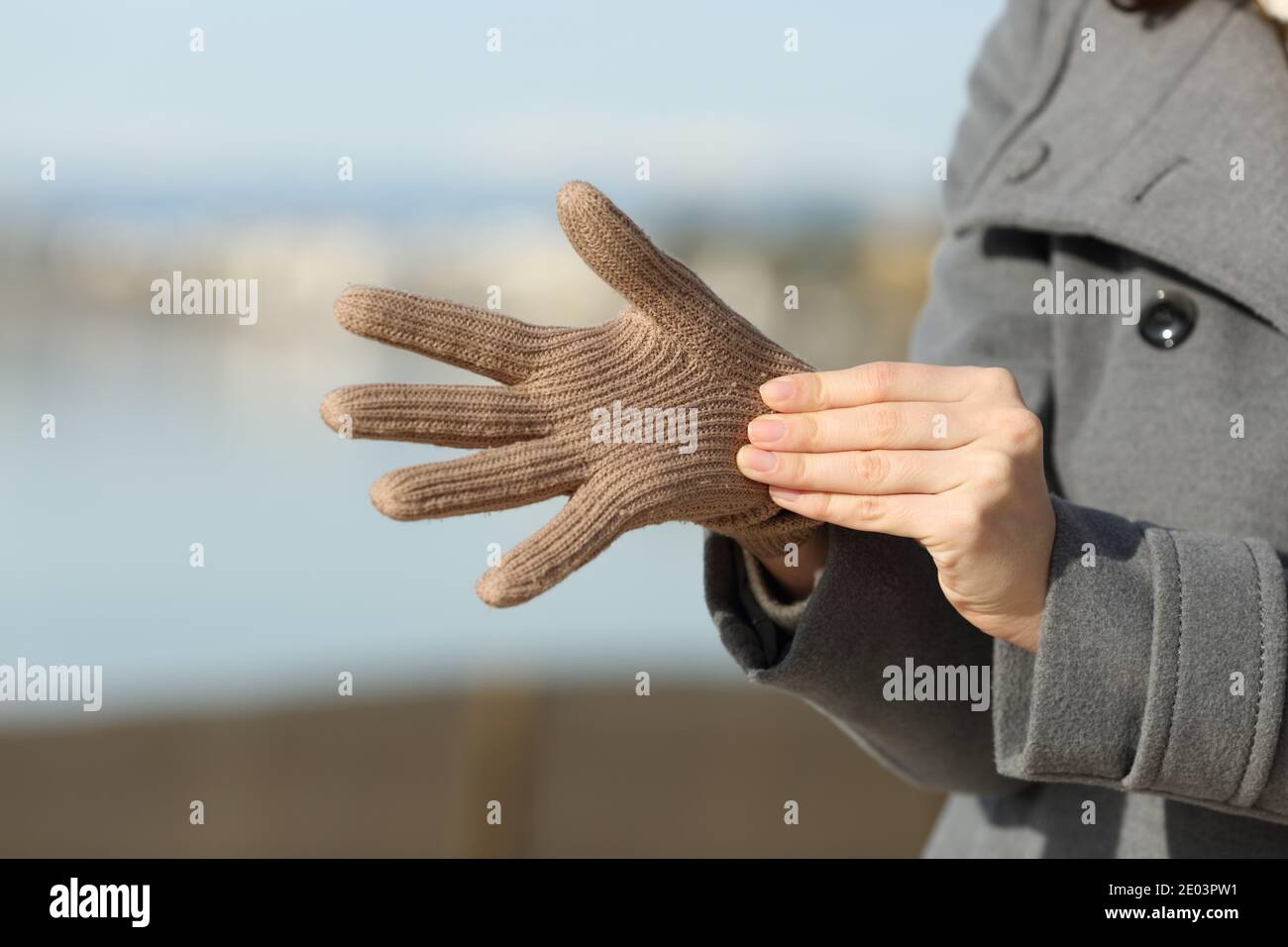 Close up of a woman hands putting gloves in winter on the beach Stock Photo Alamy