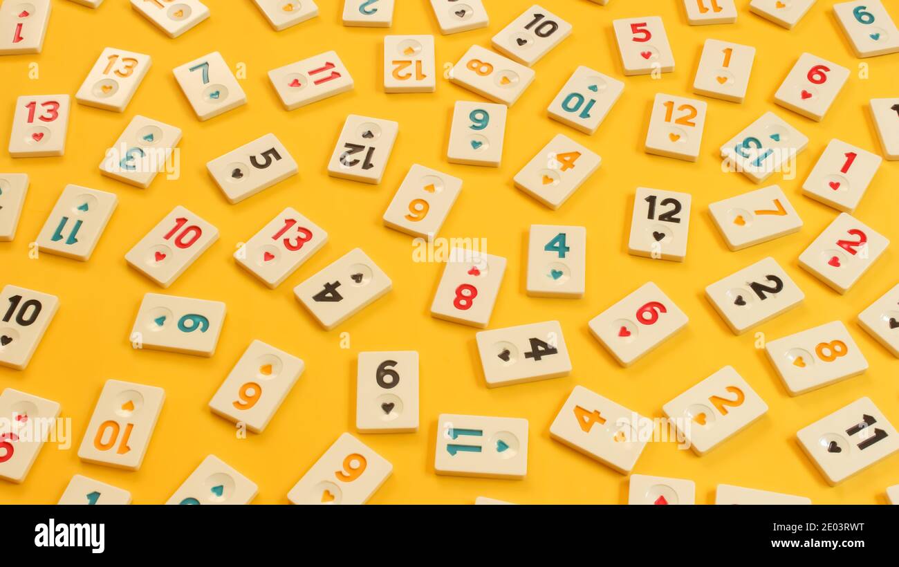 Rummikub tiles on yellow background. Colorful wallpaper. A board game