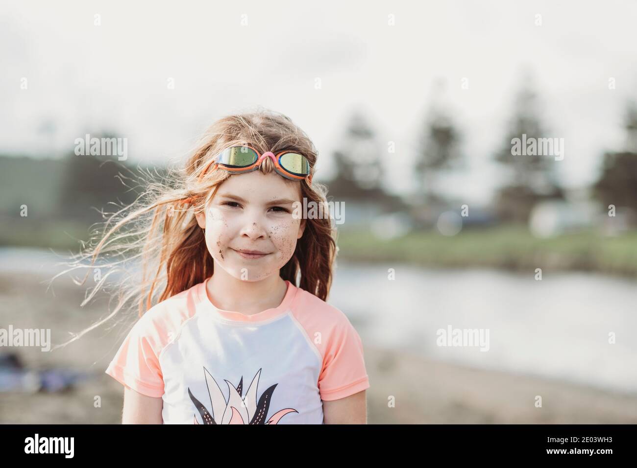 Young girl wearing googles and rash guard at the beach Stock Photo Alamy