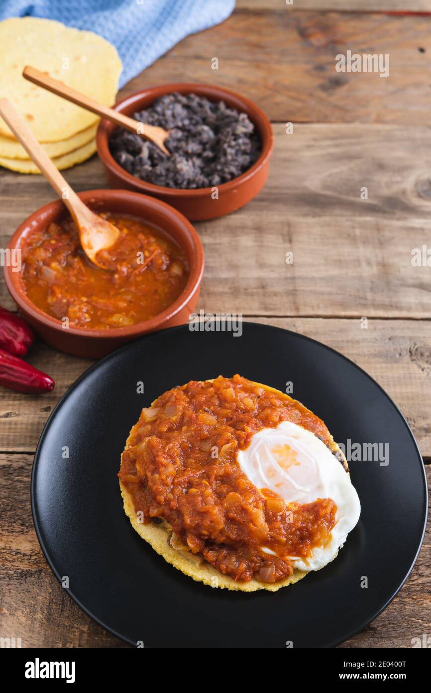 Huevos rancheros dish, Mexican breakfast on a wooden base. Mexican cuisine. Copy space. Stock Photo