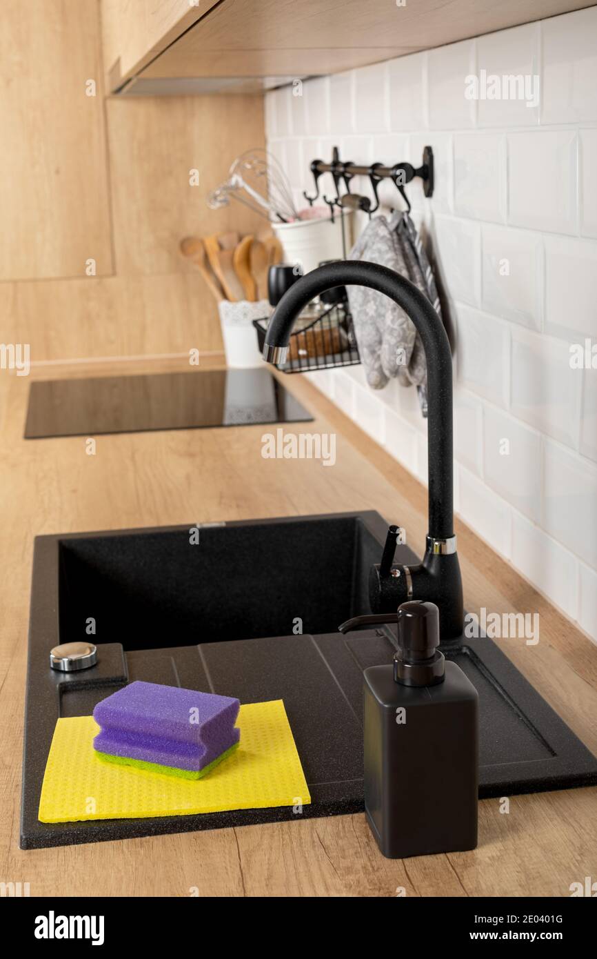 Close up picture of a clean wooden kitchen countertop and black sink ...