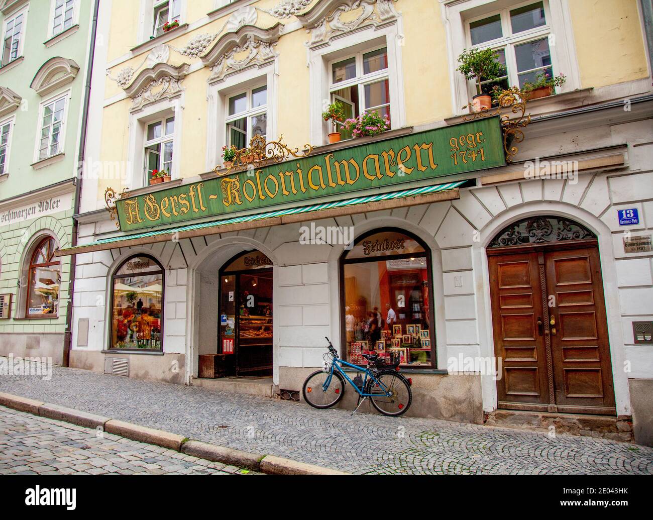Old fashioned sign sets off the baroque architecture of Gerstl Kolonialwaren, a grocery store at Residenzplatz 13,  Passau, Bavaria, Germany. Stock Photo