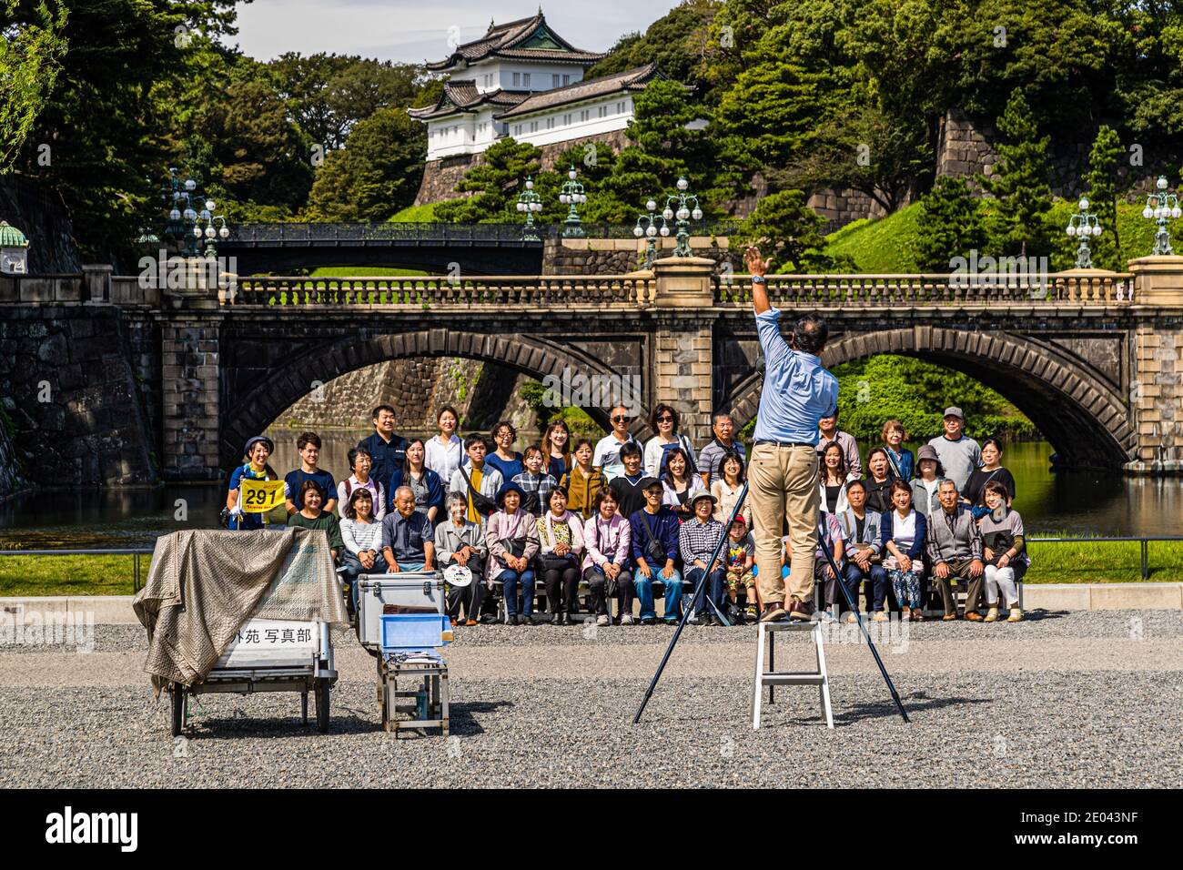 Group photographer demands attention in front of the Japanese Imperial Palace. Photoshooting in front of the Tenno Palace in Chiyoda (Tokyo), Japan Stock Photo