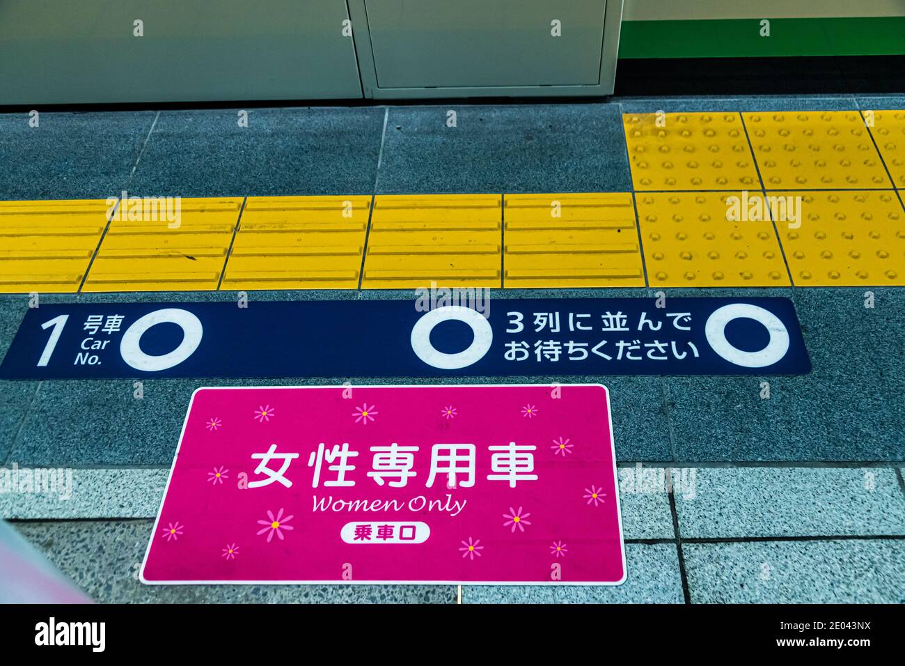 Platform-advice to indicate women's coaches in Tokyo Underground, Japan. On the platform there are train compartments for women only. Markings in the color pink on the platform indicate this Stock Photo