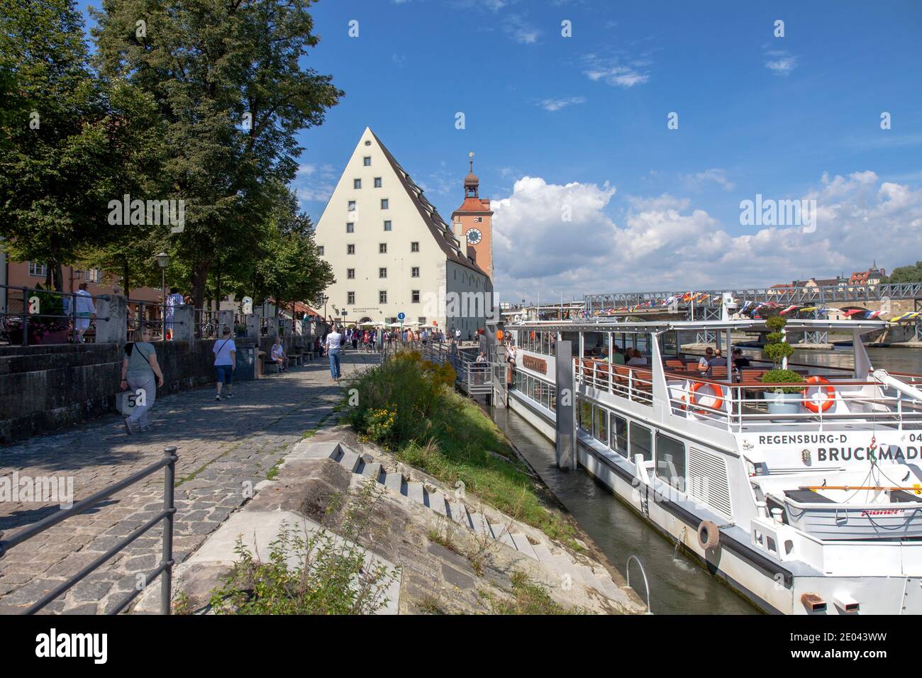 Danube quayside, with Besucherzentrum Welterbe in distance and riverboat Bruckmadl in right foreground, Regensburg, Bavaria, Germany. This museum focu Stock Photo