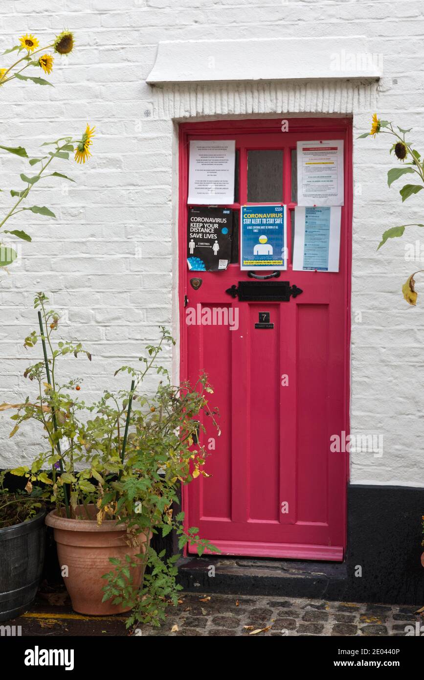 front door with covid warnings posted information , London mews London Stock Photo