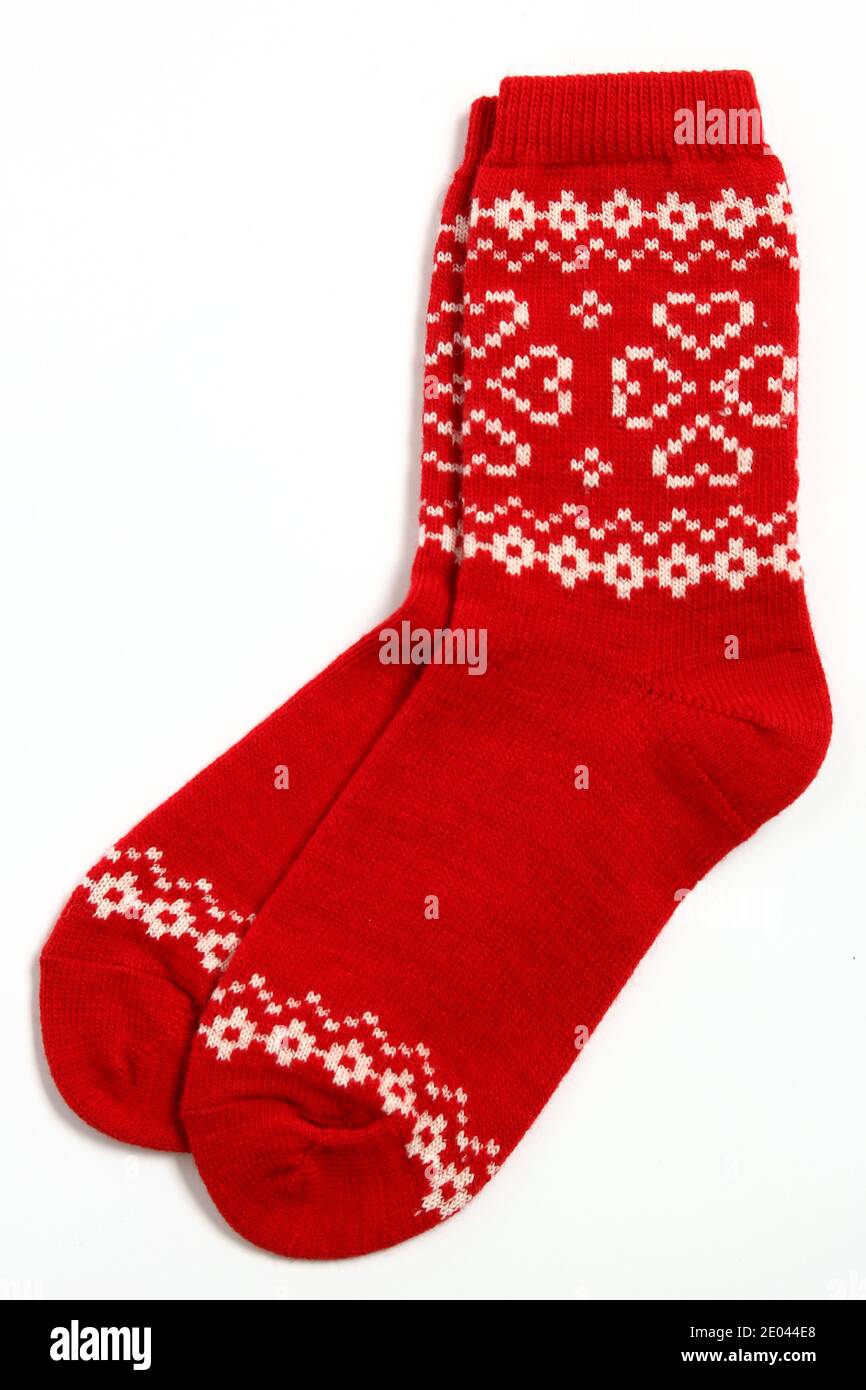 A pair of warm woolen winter socks with knitted white decorations, hearts  isolated on white background. Socks for Christmas, holiday time or cold  Stock Photo - Alamy