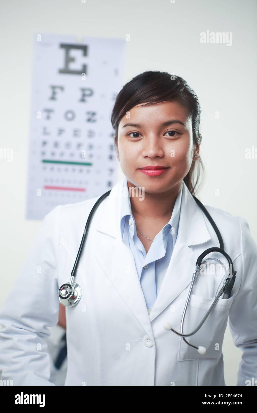 A female doctor with stethoscope and a vision chart at the back Stock Photo