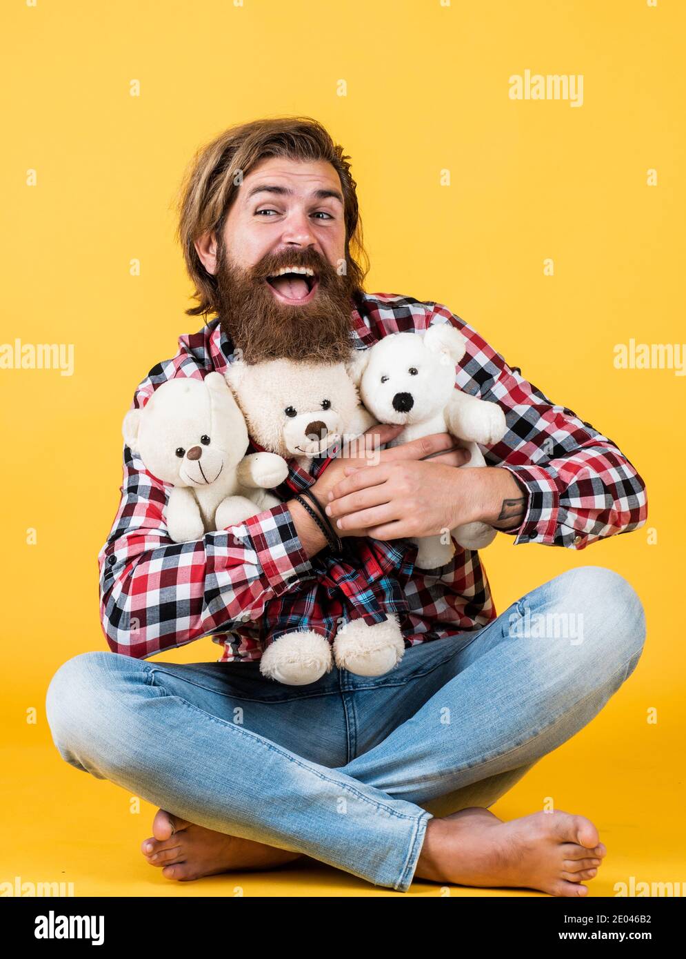 embrace with love. male feel playful with bear. brutal mature hipster man play with toy. happy birthday. being in good mood. happy valentines day. cheerful bearded man hold teddy bear. Love. Stock Photo