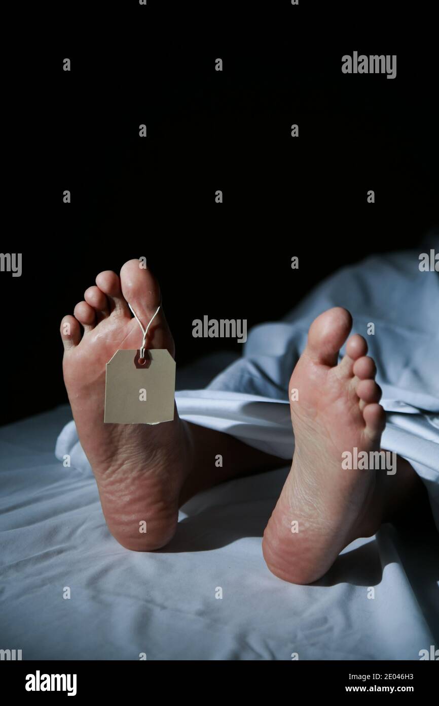 A deceased man's feet and tag in the morgue Stock Photo