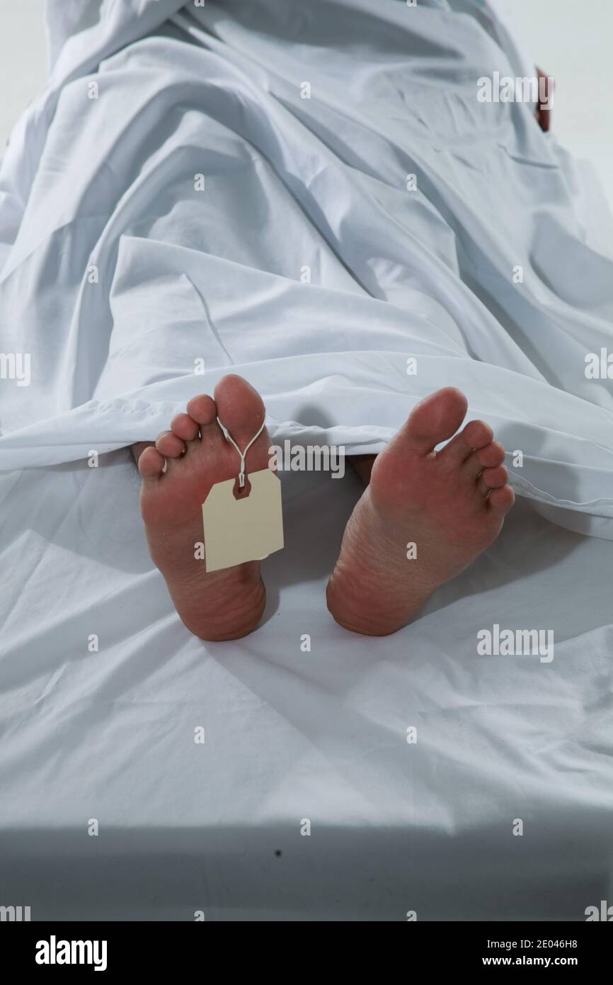 A deceased man's feet and tag in the morgue Stock Photo
