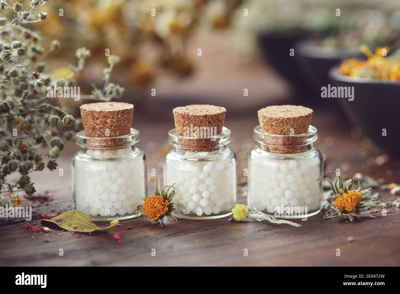Bottles of homeopathic globules and medicinal herbs. Homeopathy medicine concept. Stock Photo