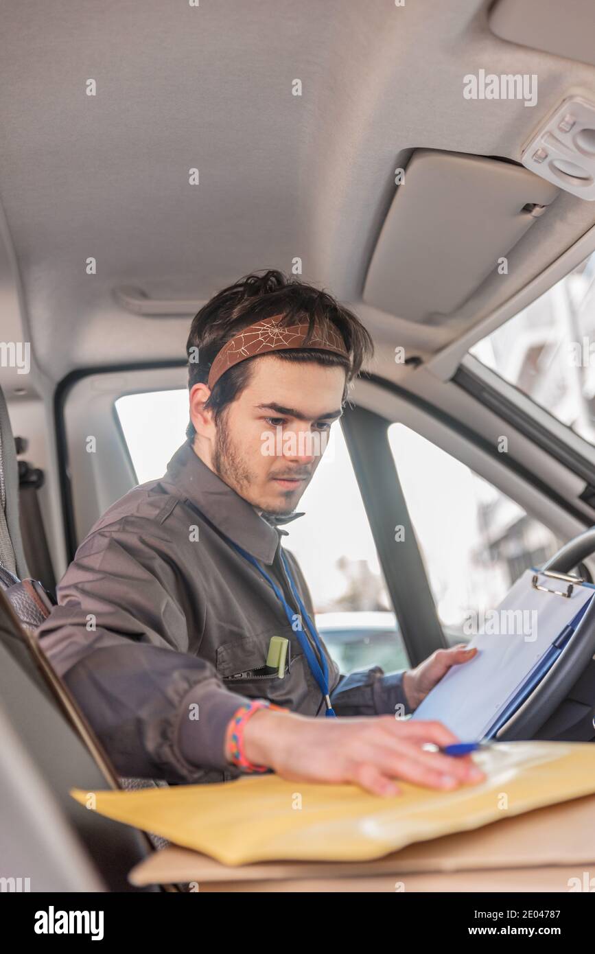 Courier in the van organising orders for delivery Stock Photo Alamy
