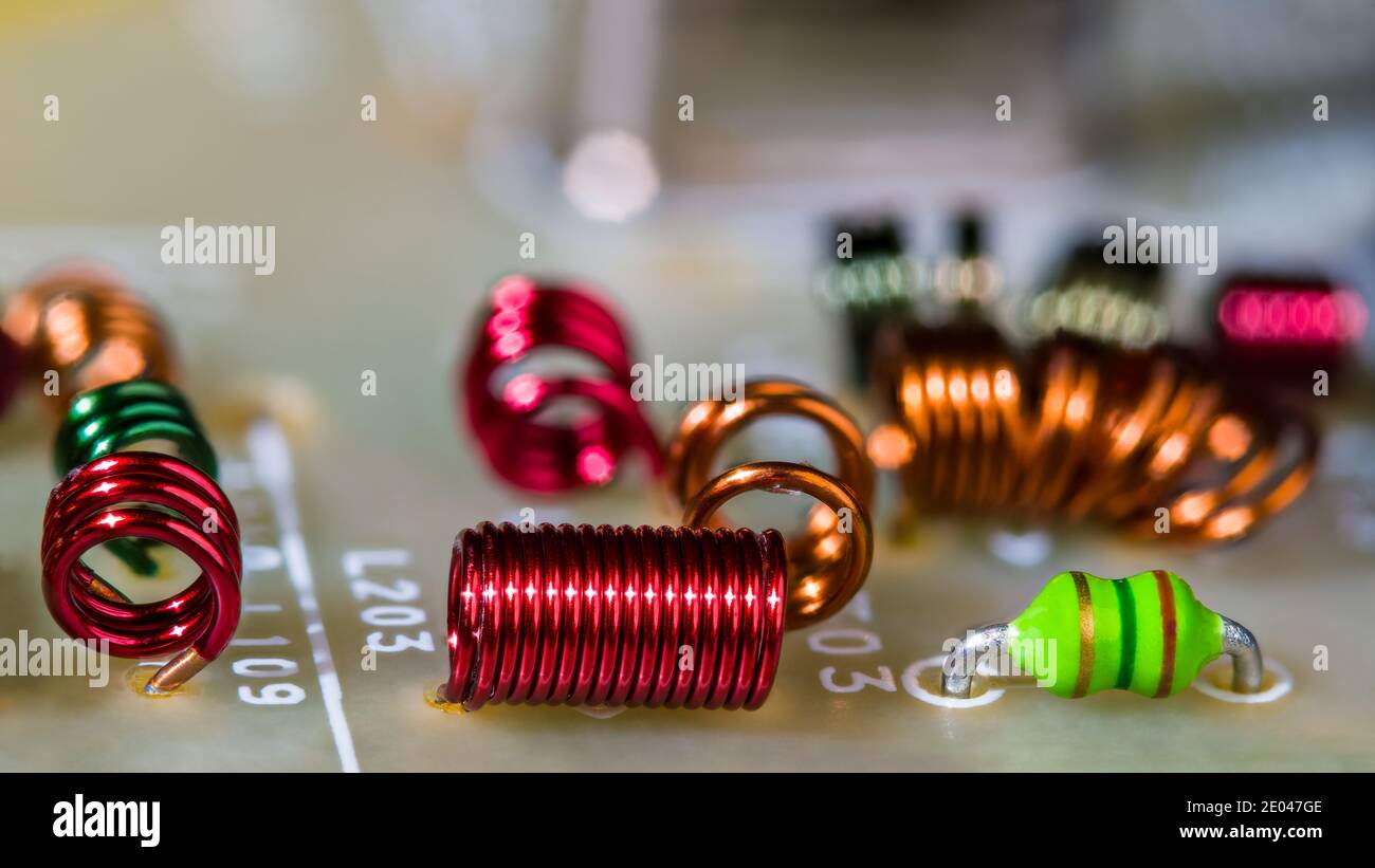 Close-up of colored air-core coils wire windings for receiving radio-frequency signal. Circuit board detail. RF electronic inductors inside TV module. Stock Photo
