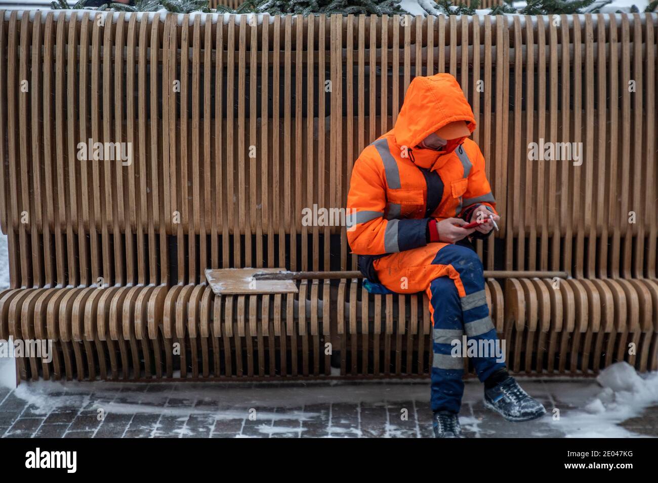Moscow, Russia. 25th of December, 2020 An employees of a municipal service wearing face masks rests after cleaning the fallen snow on Manegnaya square in the center of Moscow on New Year's Eve, Russia Stock Photo