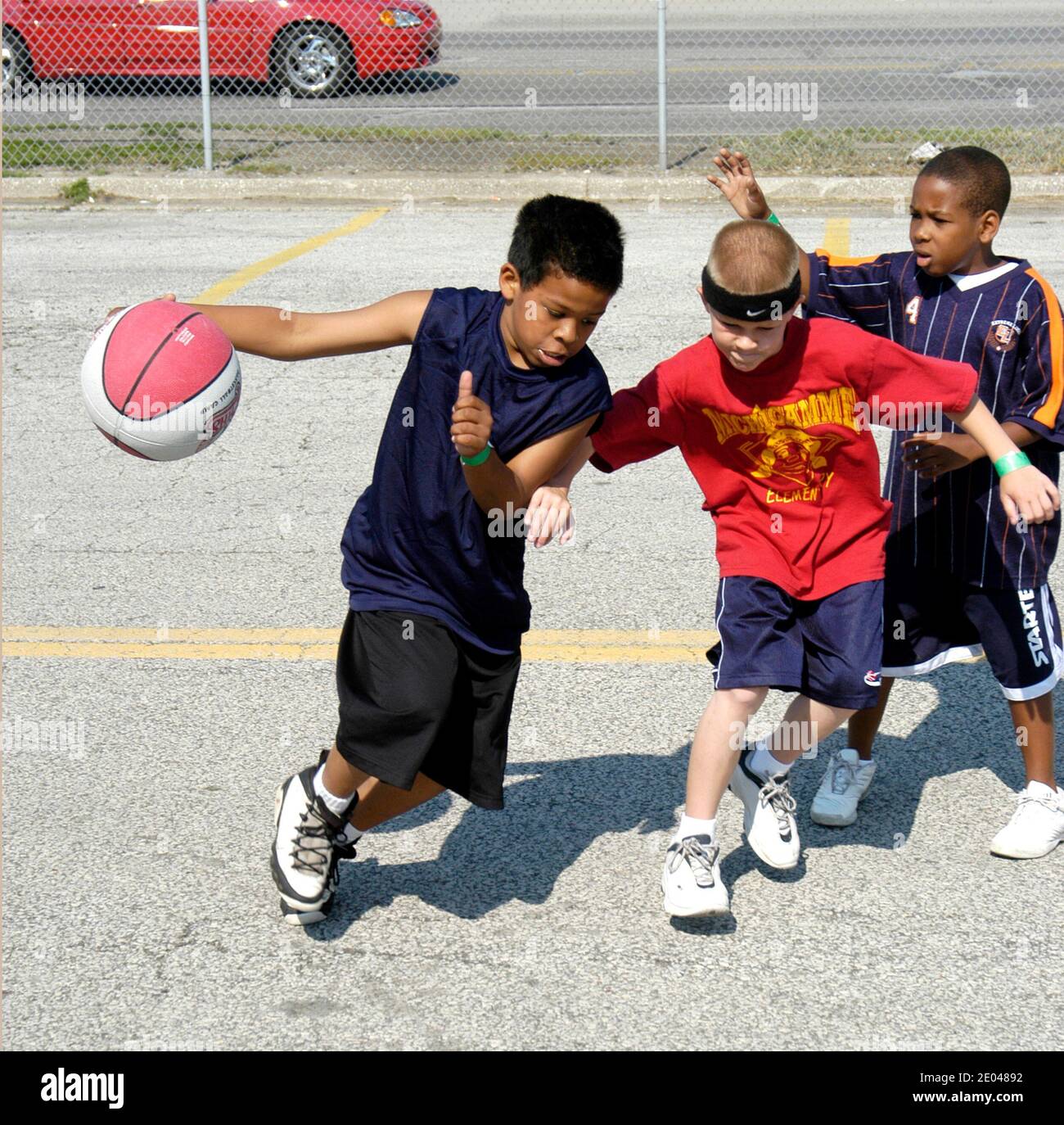 8 through 10 year old boys and girls play basketball outside in a city sponsored tournament Port Huron Michigan MI Stock Photo