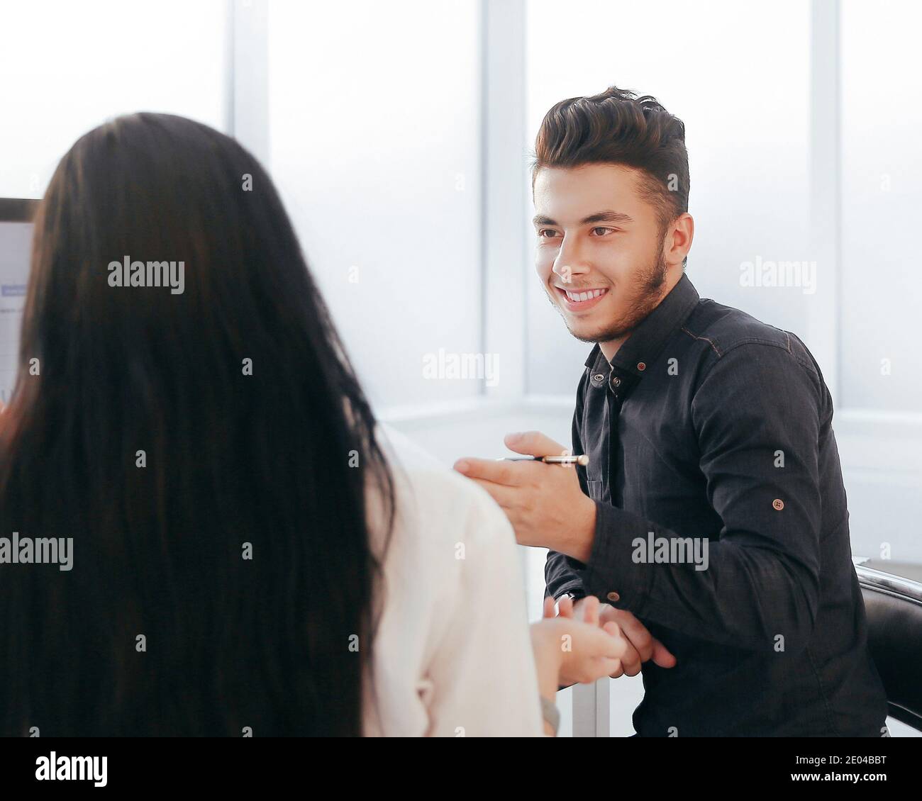 rear view. two employees discuss work issues sitting at the off Stock Photo