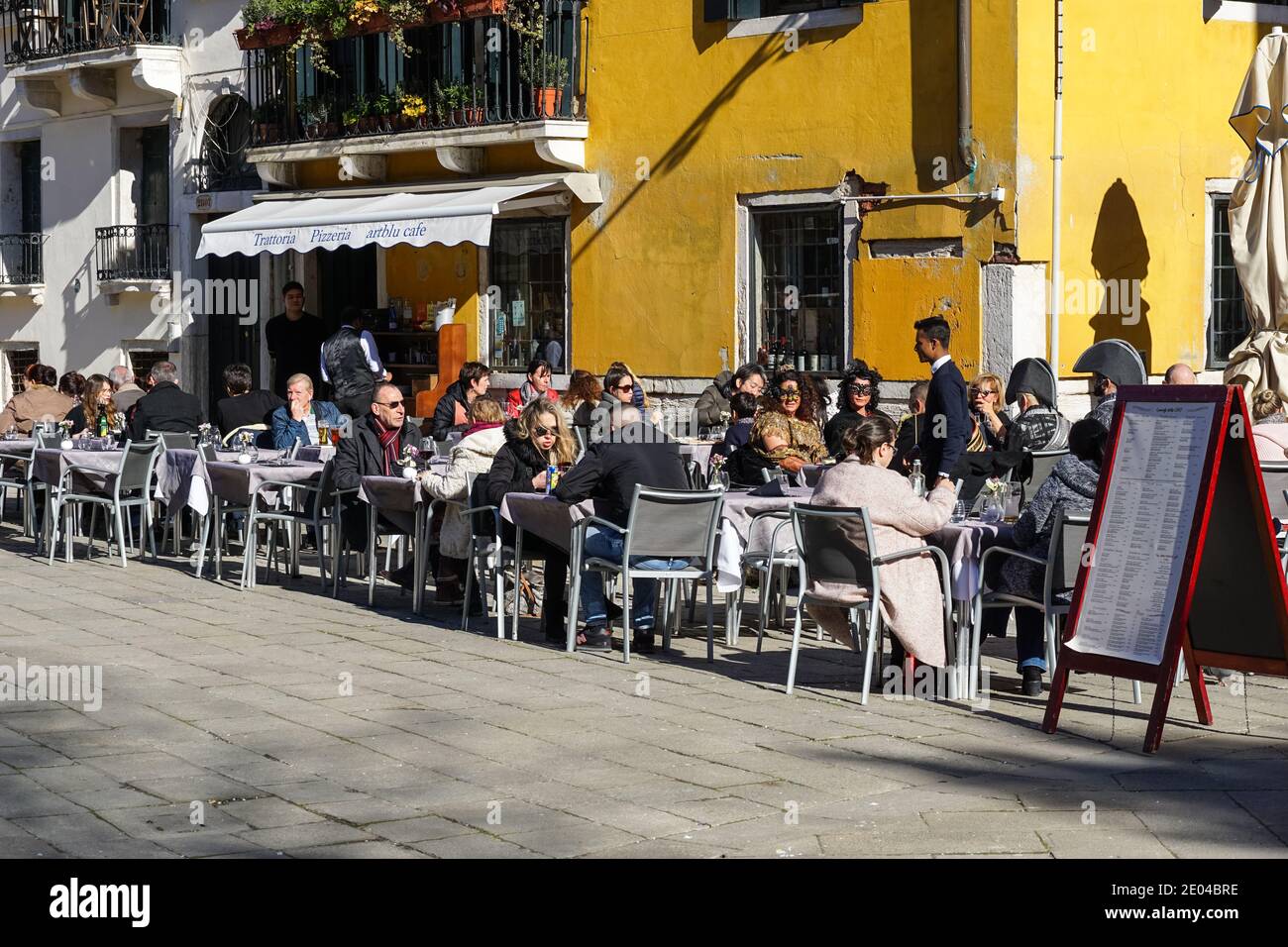 People sitting outside restaurant on Campo Santo Stefano in Venice, Italy Stock Photo