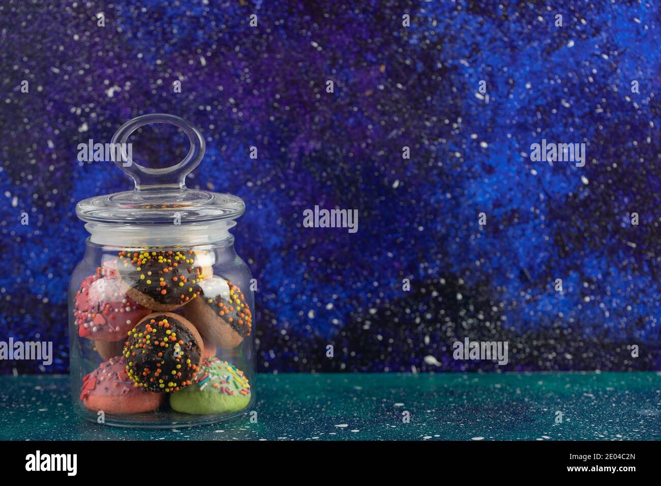 A glass jar full of small colorful doughnuts Stock Photo