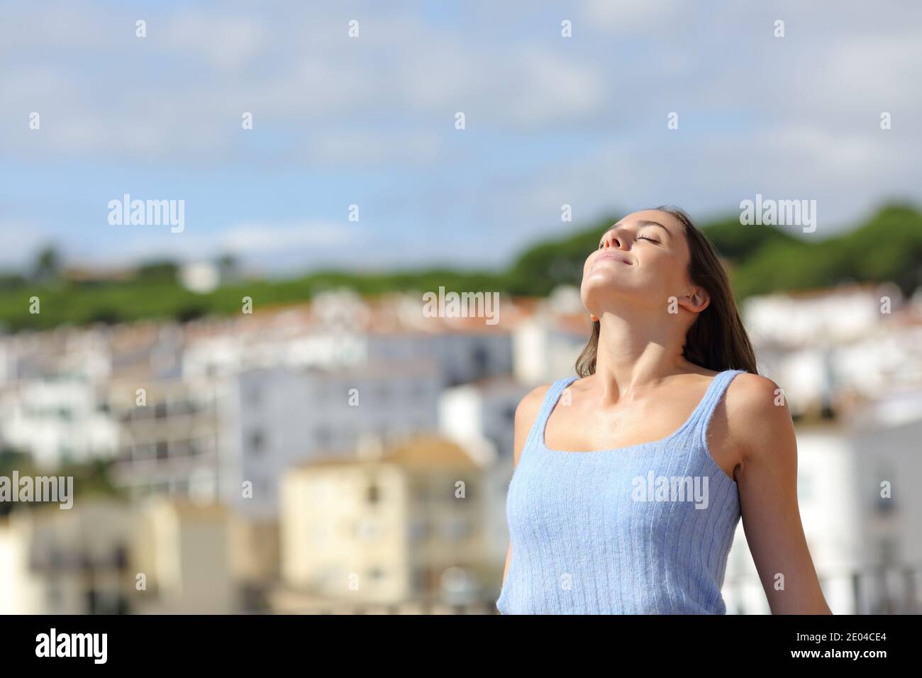 Satisfied woman relaxing breathing fresh air in a rural town Stock Photo